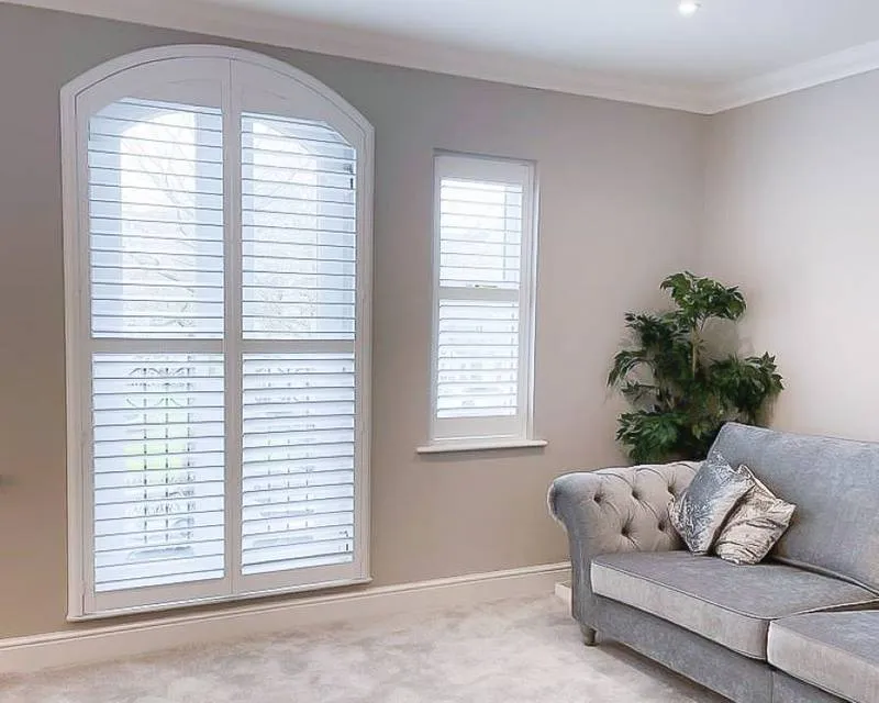 Elegant living room with plantation shutters by Shutters and Shades