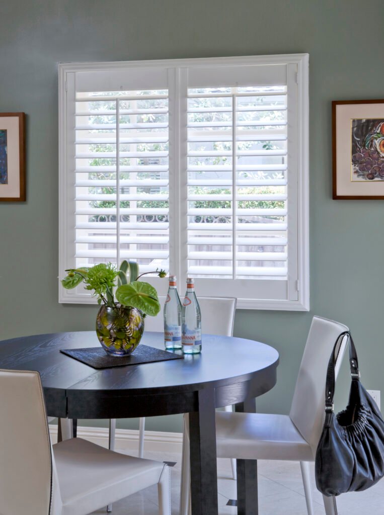 Designer adjusting Plantation Shutters inside a St. Pete Beach - FL condo near me.